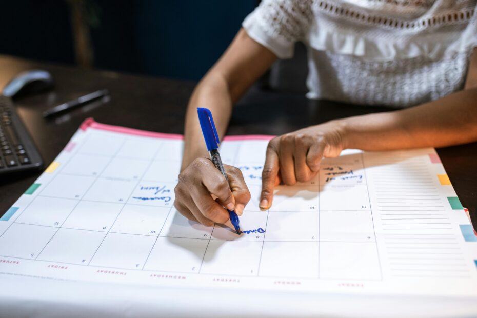 Person writing on paper calendar